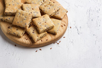 Homemade crunchy flaxseed crackers on wooden board, healthy snack with whole grain ingredients
