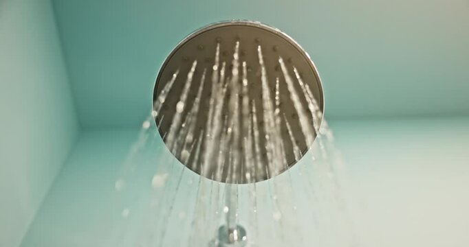 Modern shower head streaming water in bathroom