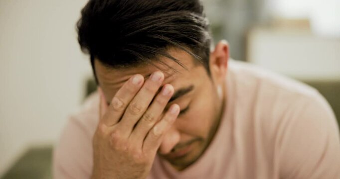Stress, depression and asian man on a sofa with mental health crisis, mistake or guilt in his home. Anxiety, burnout and face of Japanese male person in living room with trauma, worry or overthinking