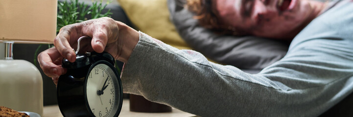 Young Male Undead Turning Off Alarm Clock Header