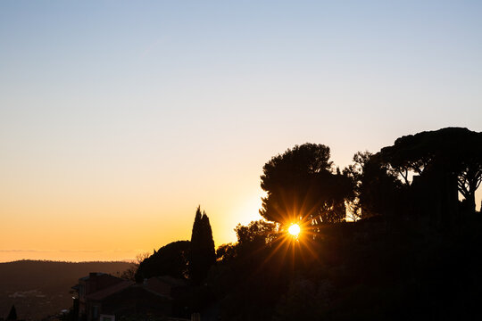 Coucher de soleil dans le sud de la France, en haut d'une colline avec vue sur le massif m&eacute;diterran&eacute;en et ligne d'horizon de pins et de cypr&egrave;s