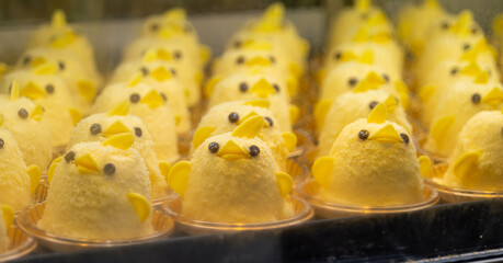 A shot into a showcase of a row of yellow Nagoya chicken-shaped famous sweets in a showcase called Piyorin. The popular sweets are made with the famous Cochin Chicken eggs.