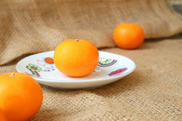 Side view of citrus fruits on a plate. Wogan Orange. with copy space