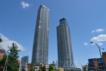 Fototapeta premium Modern skyscrapers tower over a vibrant urban landscape with clear skies and city life below