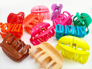 Many colorful plastic hair claw clips on white background. Woman hair accessories. Trendy...