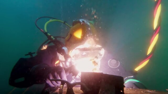 Commercial diver wet welding underwater close up