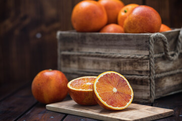 Fresh blood oranges in a basket on a wooden table