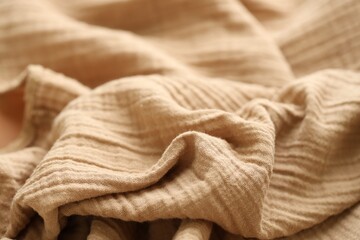 Texture of crumpled linen fabric under natural light in peach fuzz color