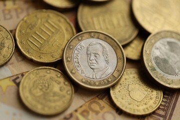 Many cent coins of euro currency lies on many fifty euro bills banknotes