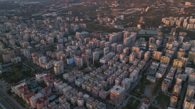 Drone view of identical residential buildings in the Mahmutlar district of Alanya, Turkey, with a mosque positioned between them in the center of the frame
