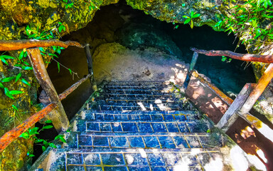 Cenote Park Yaxmuul with stairs steps into cave with water.
