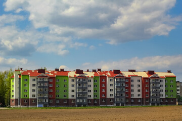 houses against the background of a blue sky with clouds. social housing, multi-storey buildings of different colors. construction.