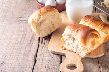 Japanese bread Shokupan, Hokkaido milk bread, or simply milk fluffy buns, on kitchen table, copy space