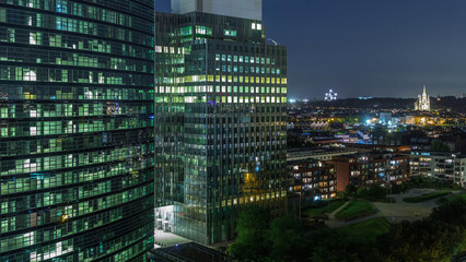 Aerial night timelapse of modern skyscrapers and towers in Brussels with glass facades and glowing...