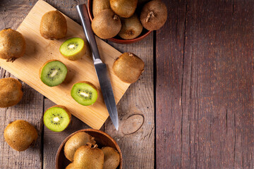 Sweet kiwi fruits, whole and sliced, on kitchen table copy space. Green and golden kiwi assortment 