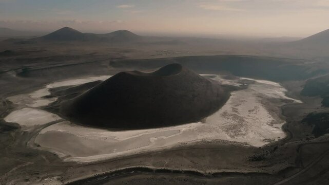 Aerial view from a drone of the black cone of Meke Lake crater with a black earth landscape in Turkey