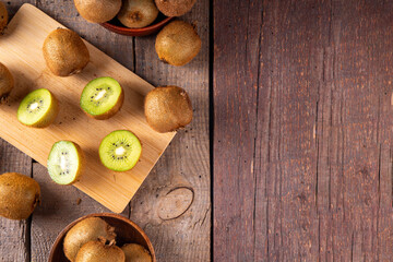 Sweet kiwi fruits, whole and sliced, on kitchen table copy space. Green and golden kiwi assortment 