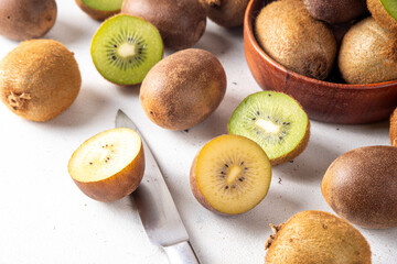 Sweet kiwi fruits, whole and sliced, on kitchen table copy space. Green and golden kiwi assortment 