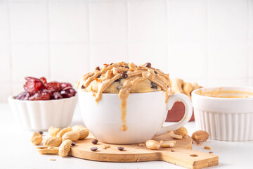 Healthy vegan Peanut Butter banana bread Mugcake, Rich and delicious peanut buttery microwave made mug cake with dates, chocolate drops, with Peanut Butter topping, nuts and chocolate