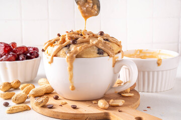 Healthy vegan Peanut Butter banana bread Mugcake, Rich and delicious peanut buttery microwave made mug cake with dates, chocolate drops, with Peanut Butter topping, nuts and chocolate