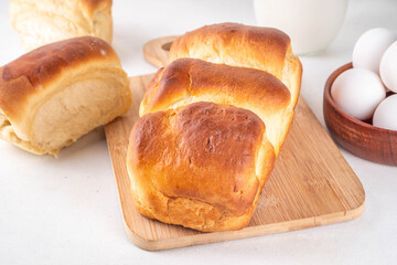Japanese bread Shokupan, Hokkaido milk bread, or simply milk fluffy buns, on kitchen table, copy space