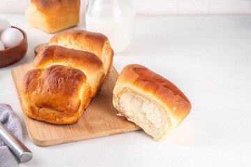 Japanese bread Shokupan, Hokkaido milk bread, or simply milk fluffy buns, on kitchen table, copy space
