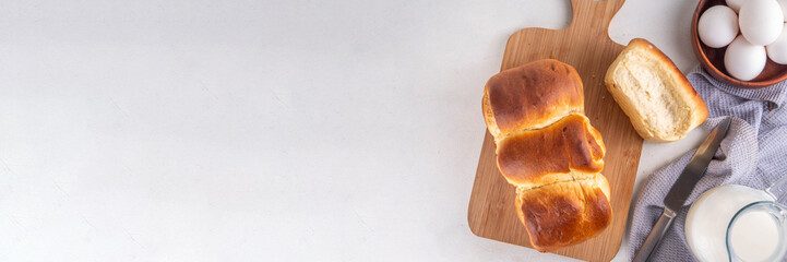 Japanese bread Shokupan, Hokkaido milk bread, or simply milk fluffy buns, on kitchen table, copy space
