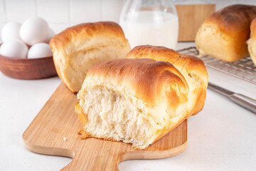 Japanese bread Shokupan, Hokkaido milk bread, or simply milk fluffy buns, on kitchen table, copy space