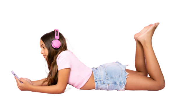 Little girl lying on the floor, using a smartphone and listening to the music. Side view. Full length studio shot isolated on transparent background.