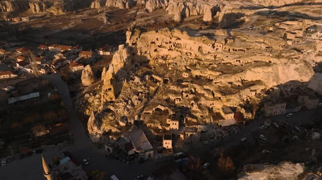 Drone view of the &Ccedil;avuşin Kalesi castle caves in the sunset rays in Cappadocia