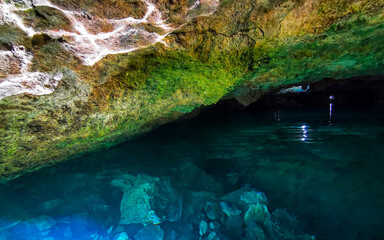 Cenote Park Yaxmuul with limestone rocks turquoise water and nature.