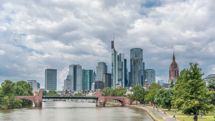 Obraz premium Hyperlapse of Frankfurt's skyscrapers skyline with the bell tower overlooking Alte Brucke. Frankfurt, Germany