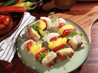 Barbecue grilled sliced ​​meat and vegetables on a wooden table