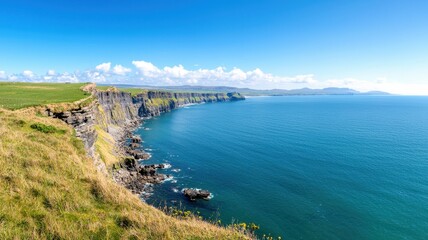 Fototapeta premium A scenic coastal view with cliffs, lush greenery, and a clear blue sky over the ocean.