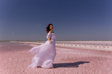 Woman White Dress Pink Salt Lake - A woman in a white dress walks on a pink salt lake with a blue...