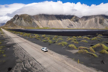 Scenic aerial view drive along remote black sands Stokksnes in Iceland surrounded by stunning...
