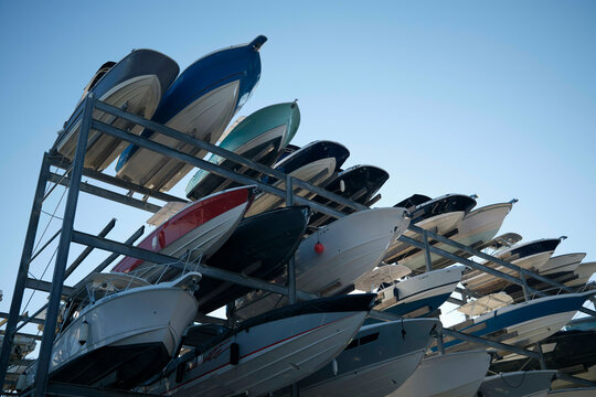 Row of colorful motorboats stacked in a metal storage structure under a clear blue sky, Miami, FLorida, USA