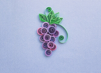 grape over made with quilling technique on blue paper background.