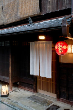Traditional Japanese storefront with a red lantern and wooden accents at dusk. Kyoto, Japan