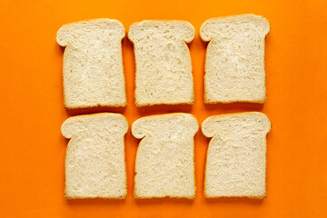 six tasty and healthy white bread slices on breakfast meal on orange background