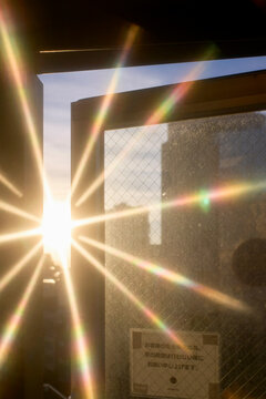 Sunlight streaming through an open window creates a starburst effect on the glass pane. Tokyo, Japan