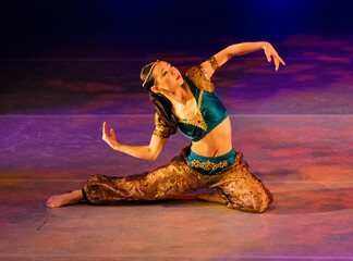 Dancer in colorful costume performs on stage with dynamic pose and vibrant lighting, The Nutcracker, Bainbridge Island, USA