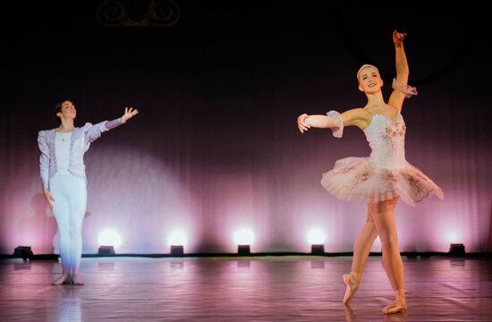 Ballerinas gracefully perform on stage in elegant costumes under soft spotlight. The Nutcracker, Bainbridge Island, USA