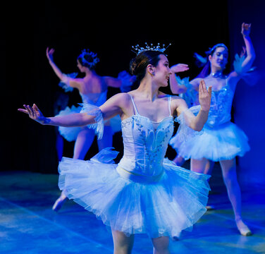 Ballet dancers in blue tutus performing gracefully on stage with spotlights. The Nutcracker, Bainbridge Island, USA