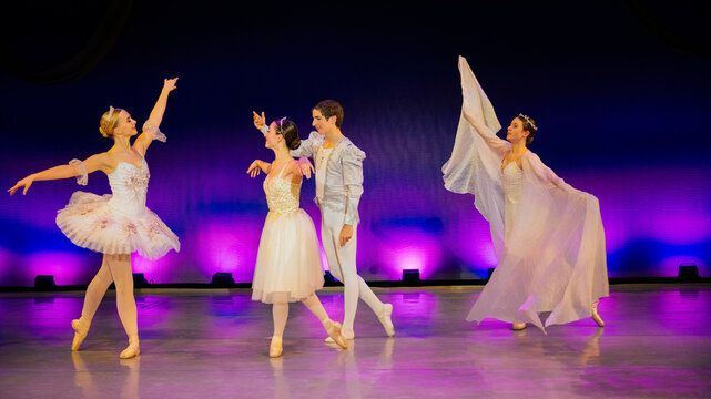Ballet dancers in elegant costumes perform on a stage with vibrant lighting. The Nutcracker, Bainbridge Island, USA