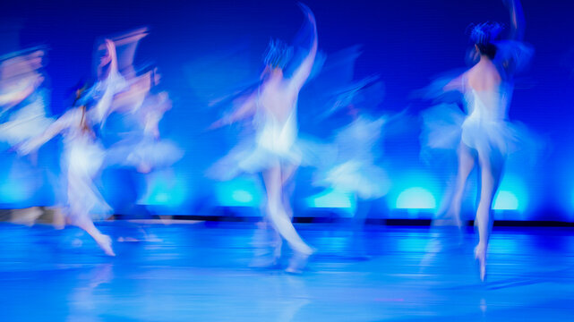 Blurred dancers in motion with blue lighting on stage and soft shadows in an abstract style. The Nutcracker, Bainbridge Island, USA