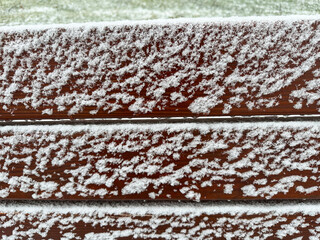 Snow on the park bench in winter time