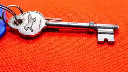 Close-Up of a Decorative Key with Horse Design on Red Background