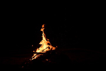 Fire flames on a black background. Burning firewood in the fireplace, close-up