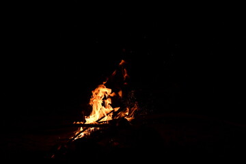 Fire flames on a black background. Burning firewood in the fireplace, close-up